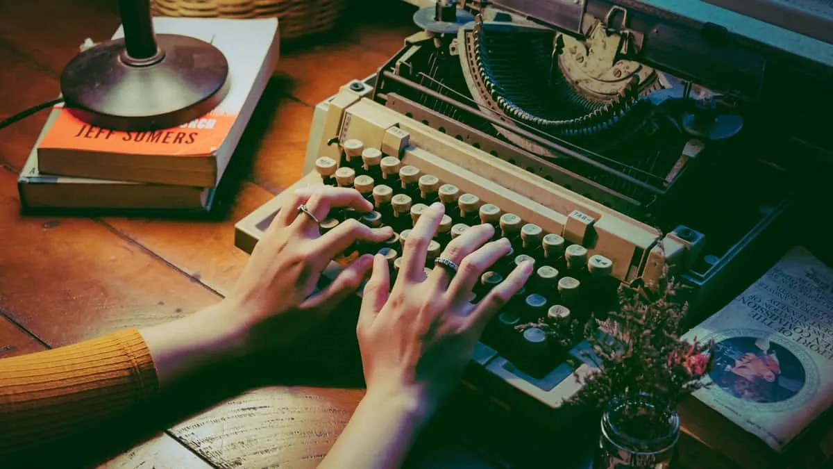 both hands typing on a typewriter